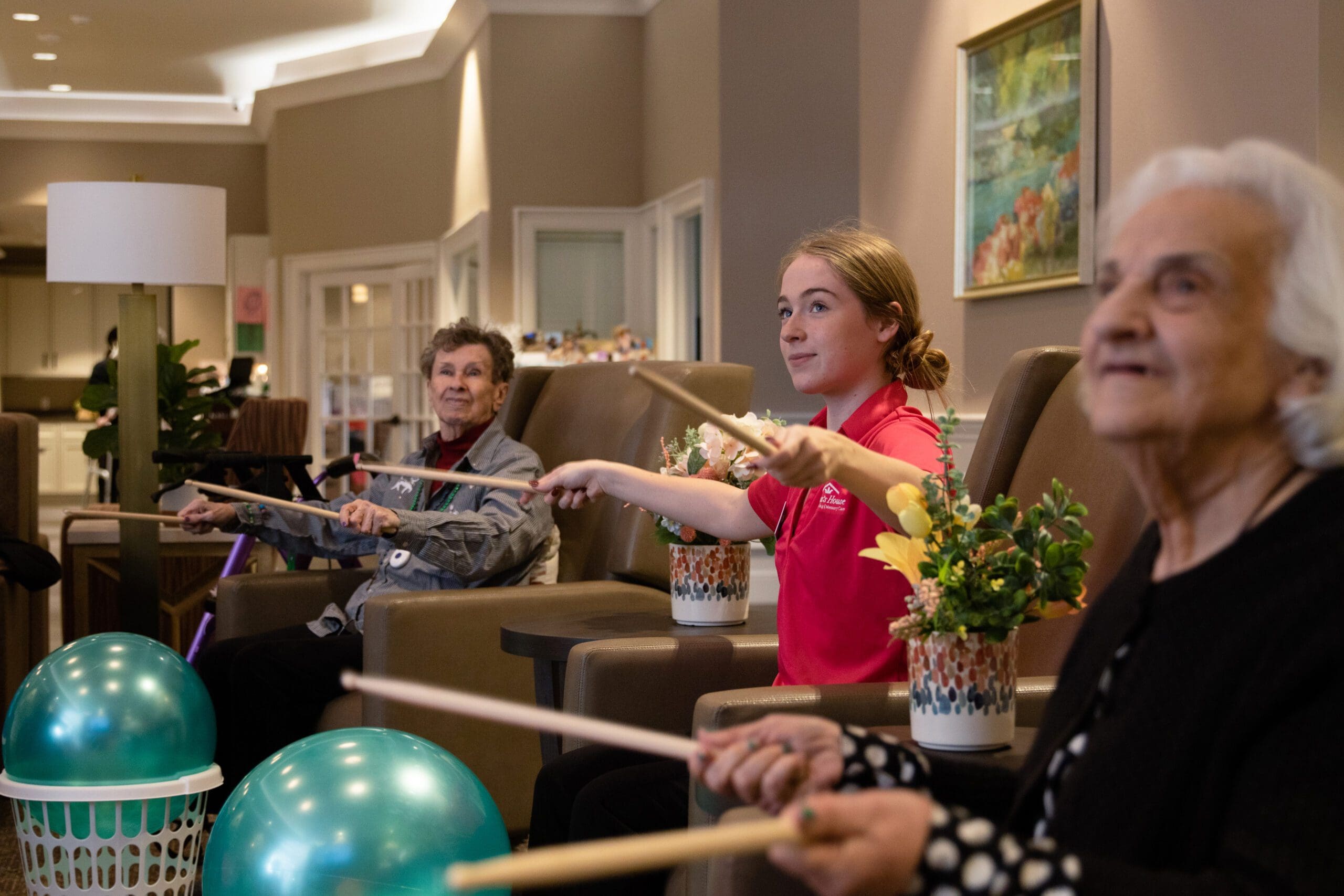 a group of people sitting in chairs holding sticks