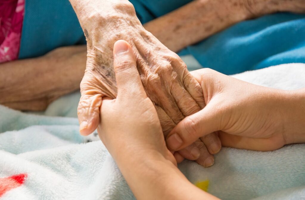 A close-up of one person holding the hand of another, offering comfort and support in a peaceful and caring environment